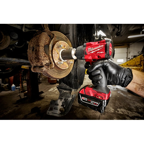 Llave de impacto Milwaukee M18 en aplicación mecánica automotriz - herramienta profesional para taller