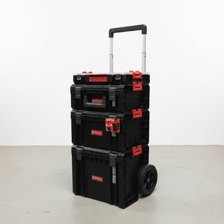 Carro con cuatro cajas organizadoras negras apiladas sobre base con ruedas y asa telescópica extendida